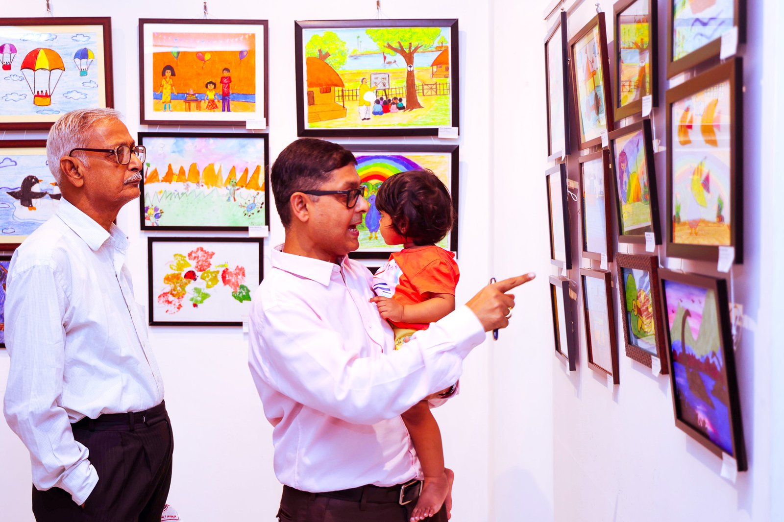 Families appreciating children’s artworks