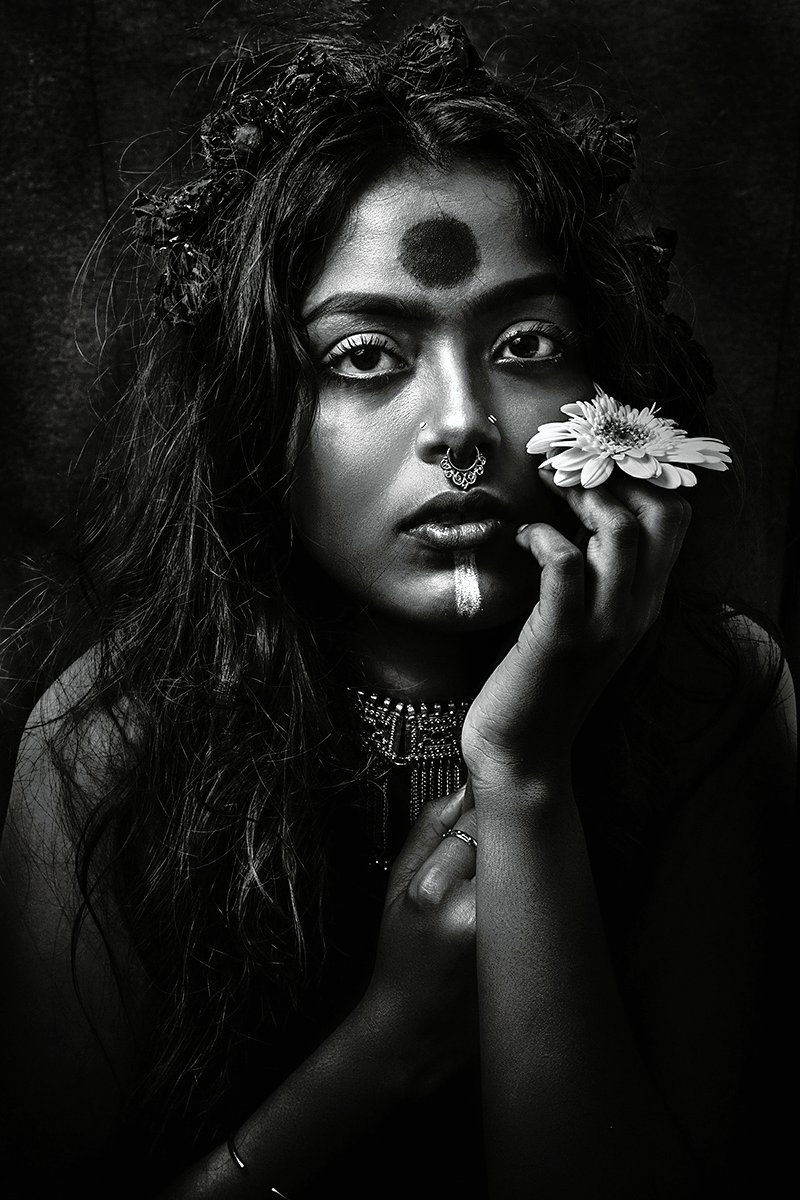 Arpan Dutta Chowdhury: Black, White & In Between 5 Studio portrait of a woman with large bindi and nose rings, a flower ring resting on her cheek, black-and-white.